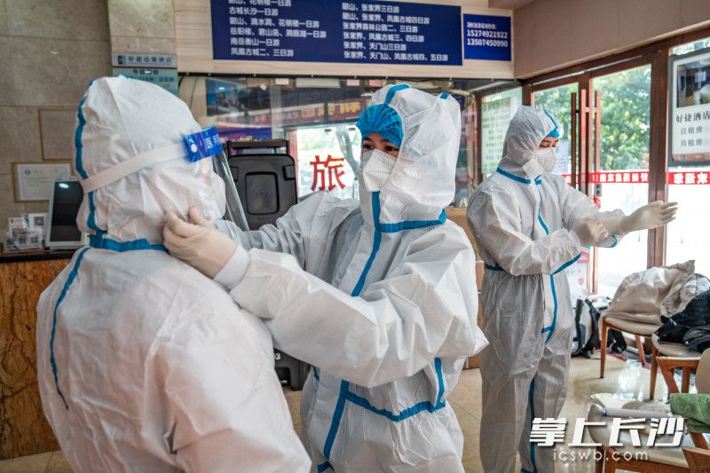朝阳街道社区卫生服务中心核酸采样人员在清洁区穿戴防护装备，正准备进入隔离区为被隔离人员核酸采样。