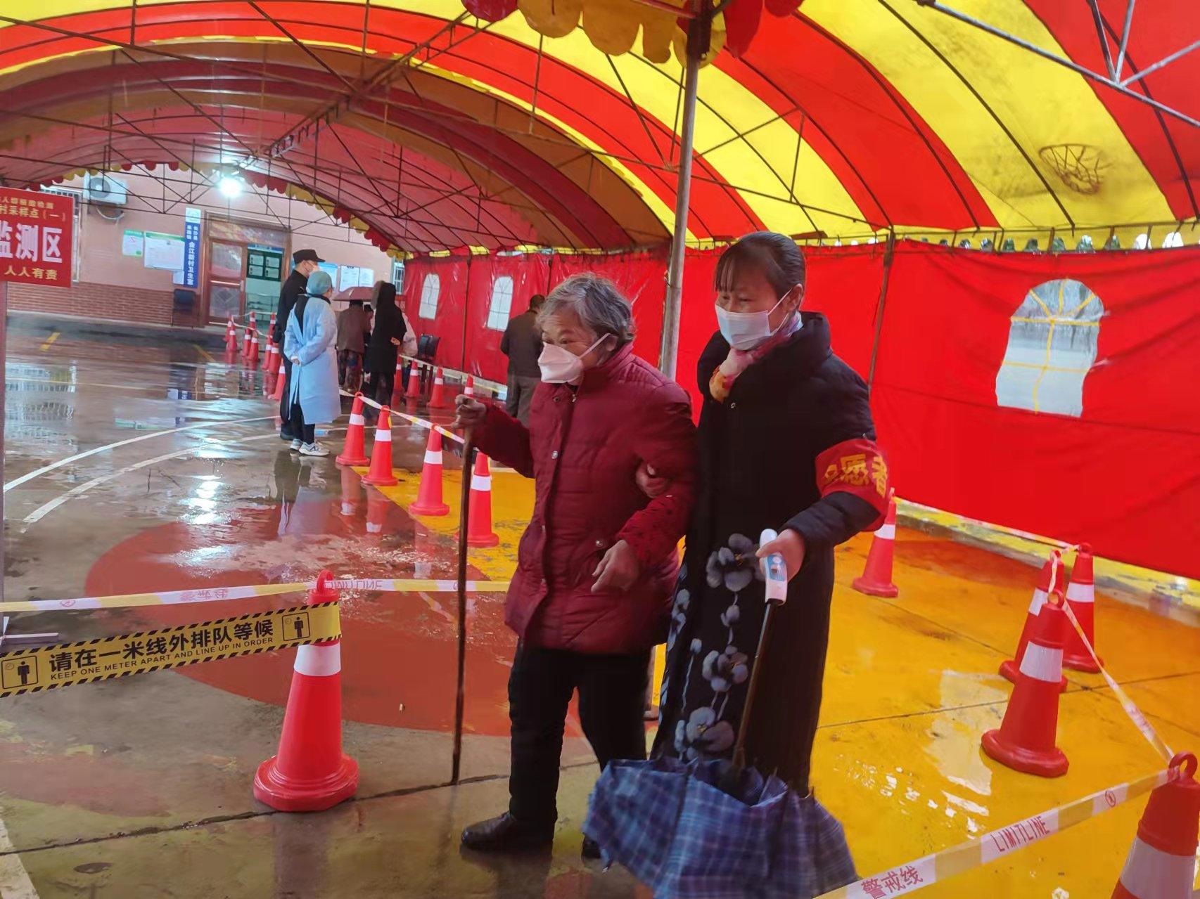 长沙县果园镇，雷锋志愿者正用温暖的手搀扶老人到参检台参加核酸检测。 长沙晚报通讯员 曹丹 拍摄
