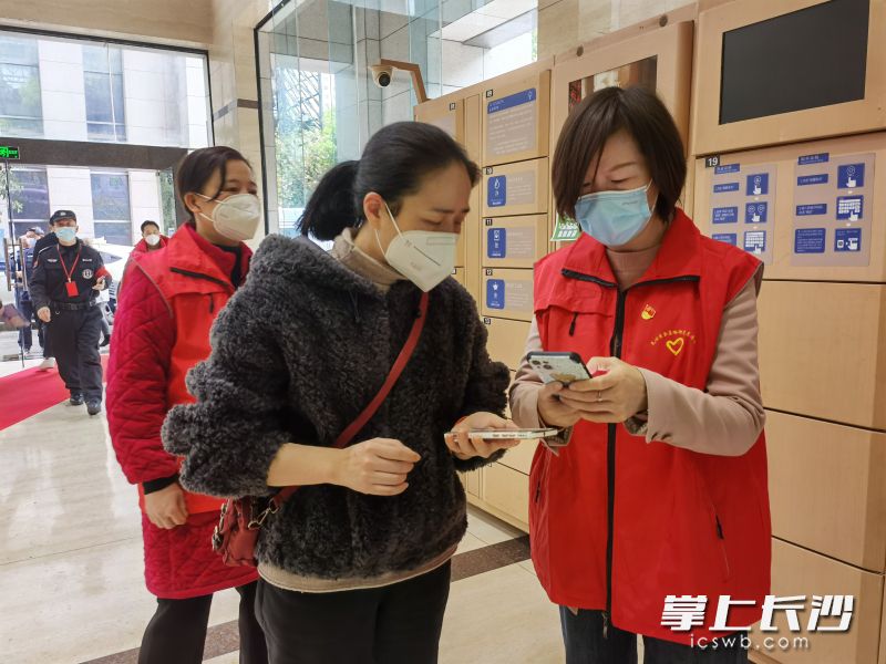 五十七度湘党员志愿者引导楼宇企业员工扫场所码。长沙晚报通讯员 石琛 供图