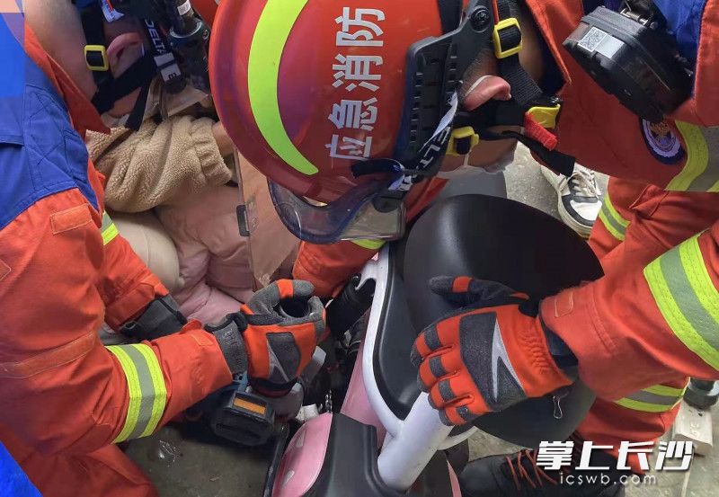 现场，消防员剪断电动车链条，将女孩的手取出。长沙晚报通讯员 杨慧 供图