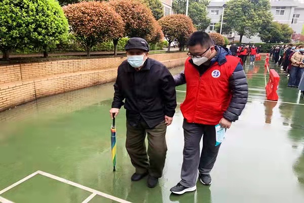 志愿者扶着高龄老人去做核酸检测，并为他们开辟优先检测的绿色通道。长沙晚报通讯员 邹斯 供图