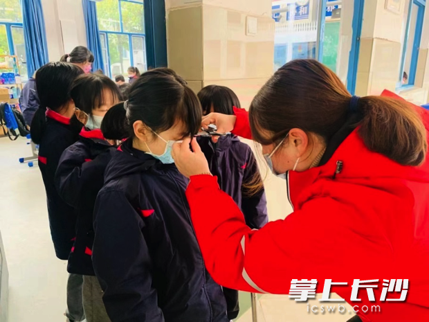 女生们排队让老师剪留海。照片由学校提供。