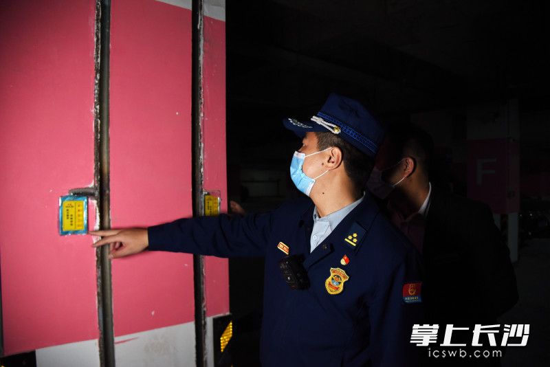 在地下室，消防监督员现场测试消防卷帘是否正常运行。