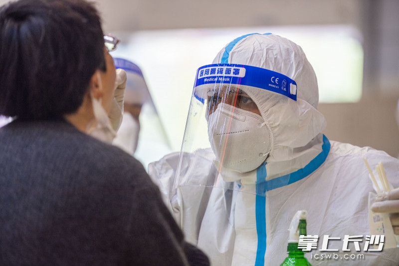 代宇为湖南工商大学师生进行核酸检测采样。