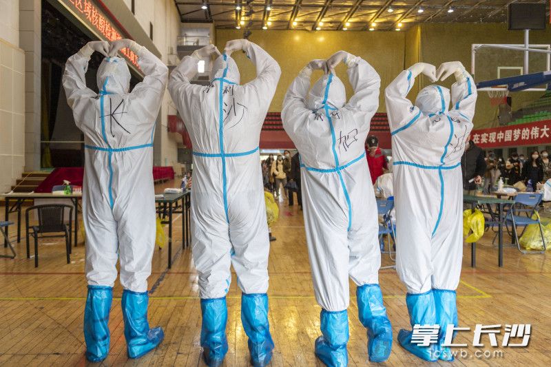 萨利、代宇和小伙伴身穿写有“长沙加油”字样的防护服合照。