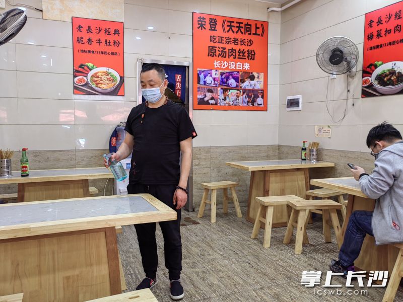 湖南米粉街老长沙原味粉店对餐桌定时消毒。
