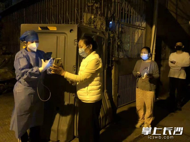 7日晚9时，赵莹（左）在管控区进行核酸采样。受访者 供图