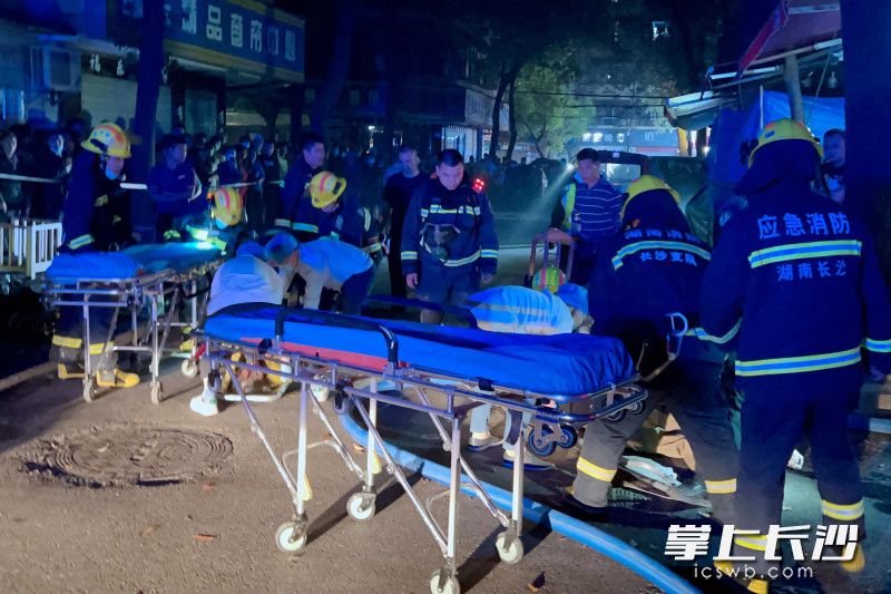 消防员将两名伤者转交给现场医务人员。长沙晚报通讯员 陈紫阳 供图