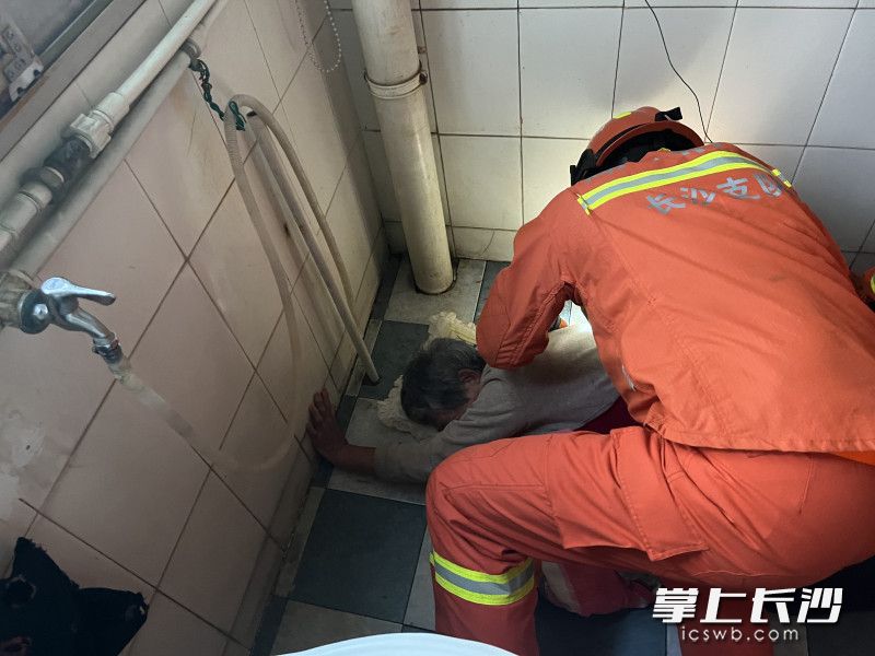 现场，消防救援人员对老人展开救援。长沙晚报通讯员 寻艳 供图