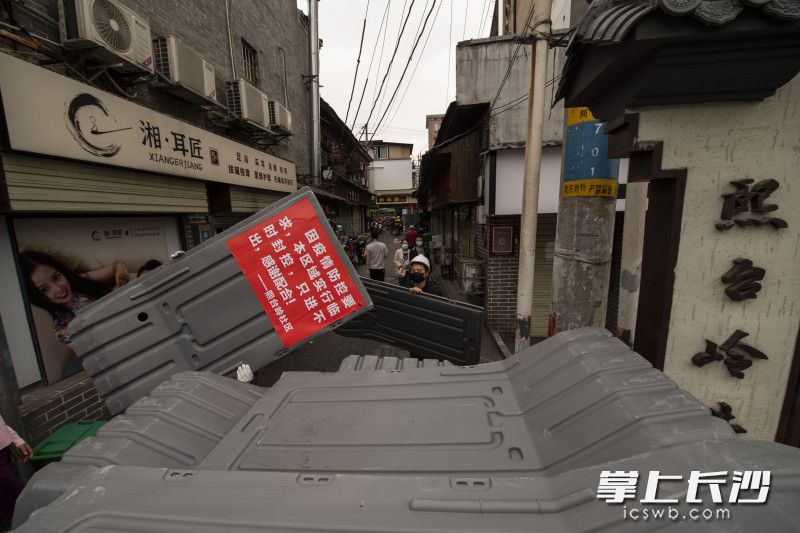 在城南路熙台岭巷口，工人们正在搬离用于隔离的护栏。均为 长沙晚报全媒体记者 黄启晴 郭雨滴 摄