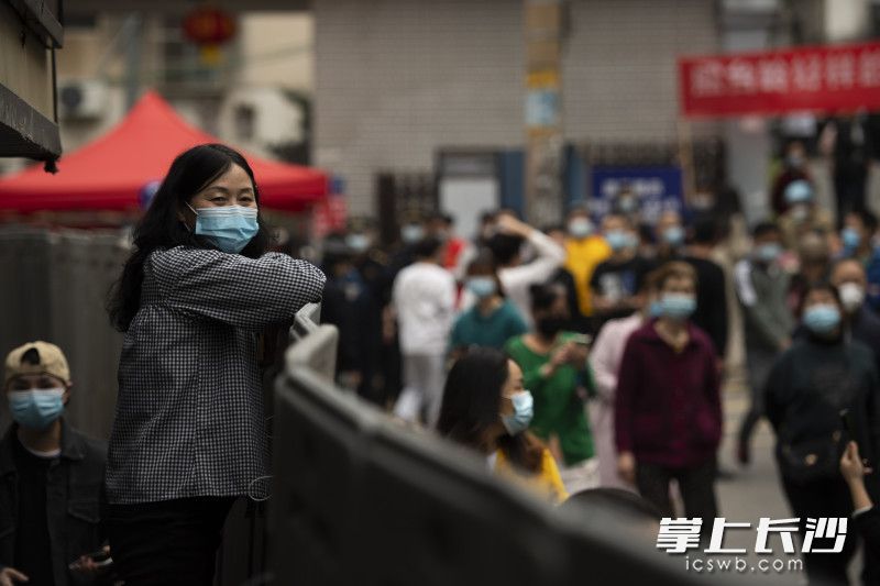一位居民隔着护栏看着外面。