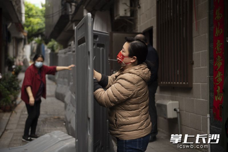 巷子里，居民与志愿者一起拆除隔离护栏。