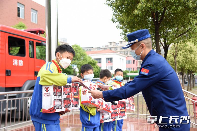 “火焰蓝”为四名带路少年送上消防车模型、课外书籍等奖励。长沙晚报全媒体记者 刘琦 摄