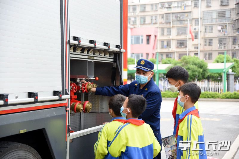 消防员为四名少年讲解消防车上的设施和装备。长沙晚报全媒体记者 刘琦 摄