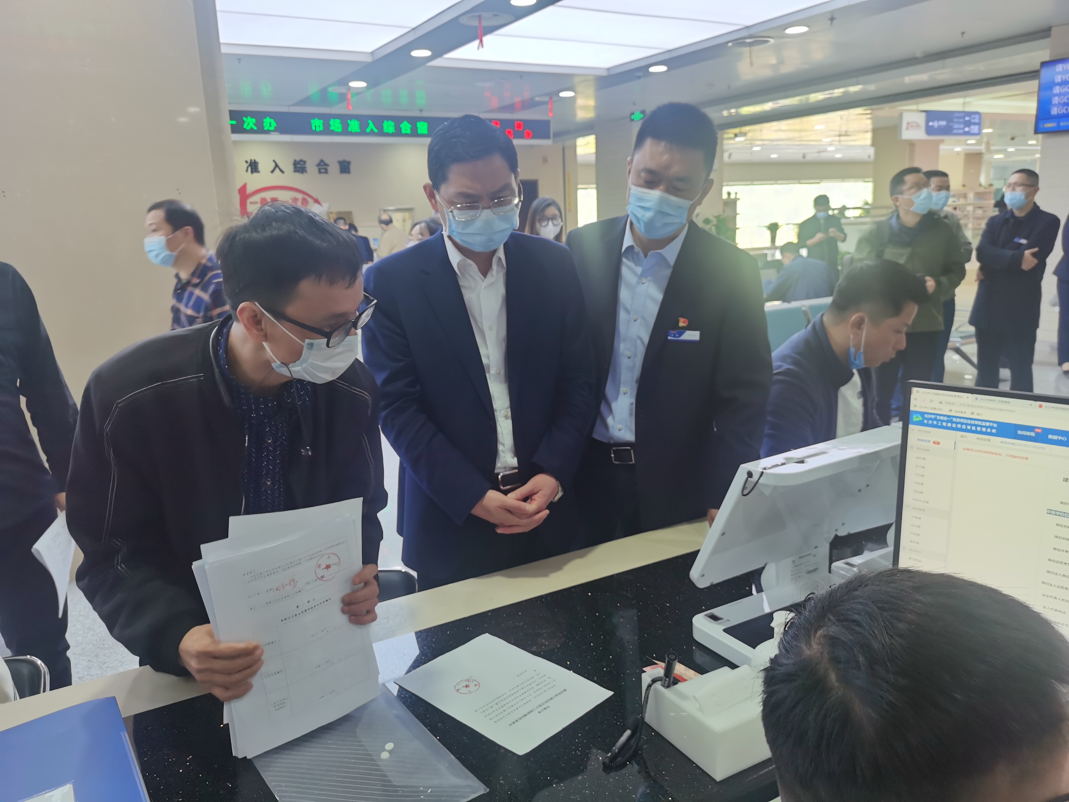 长沙市行政审批服务局党组书记、局长杨应龙（左二）走进各办事窗口，以企业群众视角“走流程”，采取“陪伴走”的方式，面对面为群众解难题。 长沙晚报通讯员 曹明 供图
