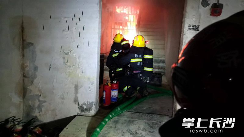 在地下车库，消防救援人员出水枪控制杂物间火势。长沙晚报通讯员 刘雅莉 供图