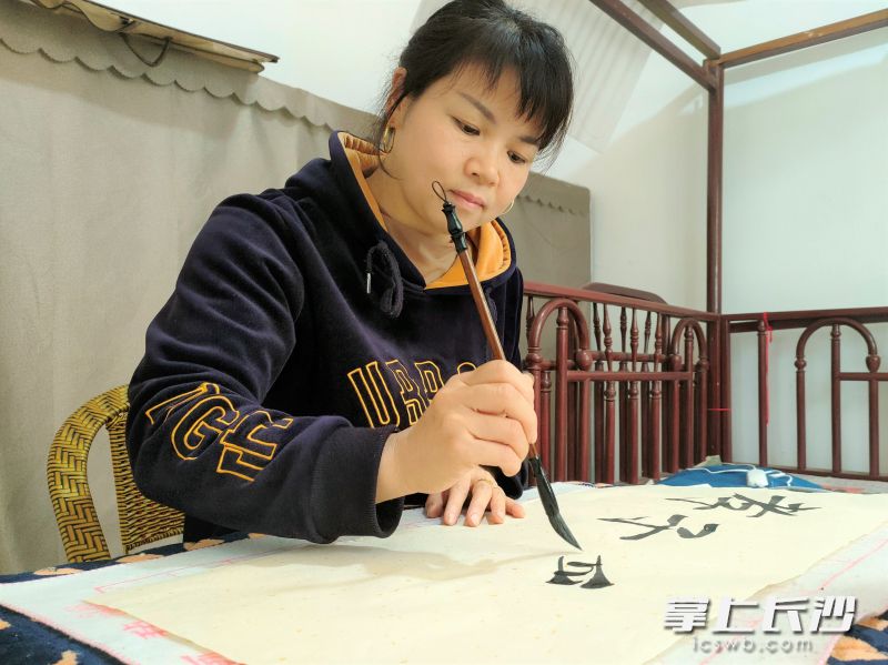 把家人们安顿妥帖之后，李宁波喜欢练字陶冶情操。长沙晚报全媒体记者 张禹 通讯员 李向 周杰 摄影报道