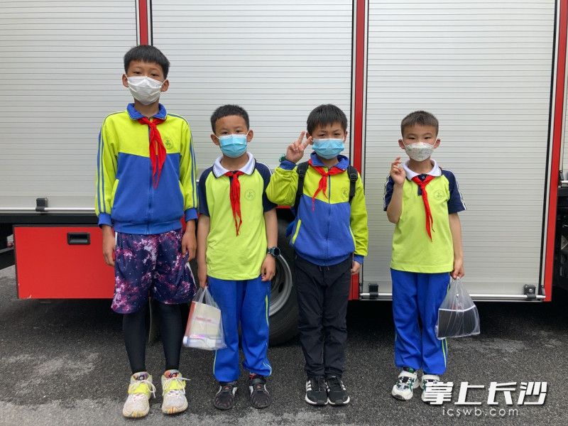 四位带路少年在消防站开心合影。