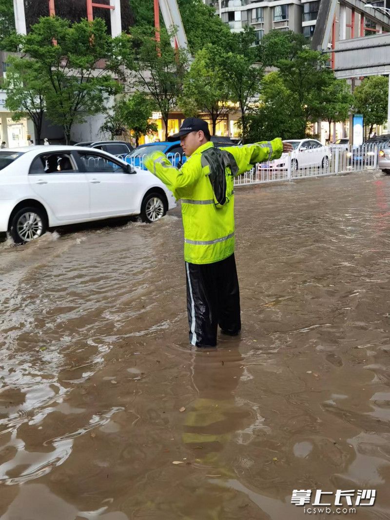 开福交警大队铁骑中队协警黄科在疏导交通，充当“水位尺”。