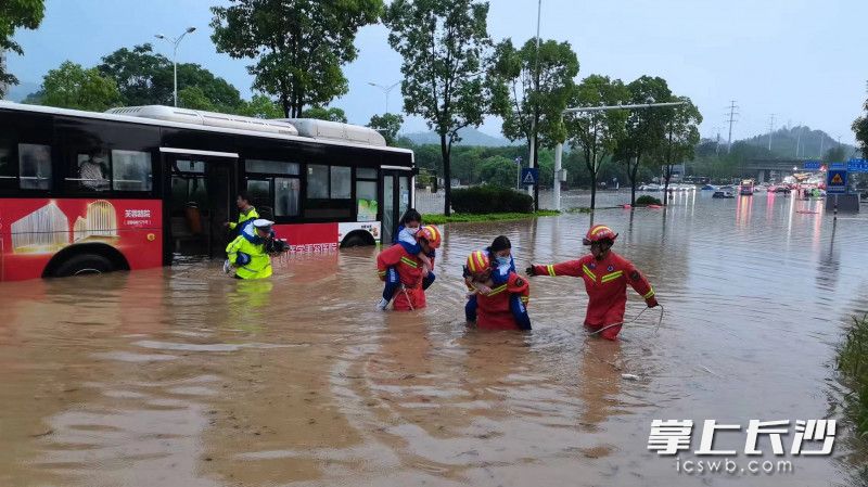 在岳麓区积水路段，消防救援人员和交警一起从公交车上转移被困群众。长沙晚报通讯员 刘雅莉 供图