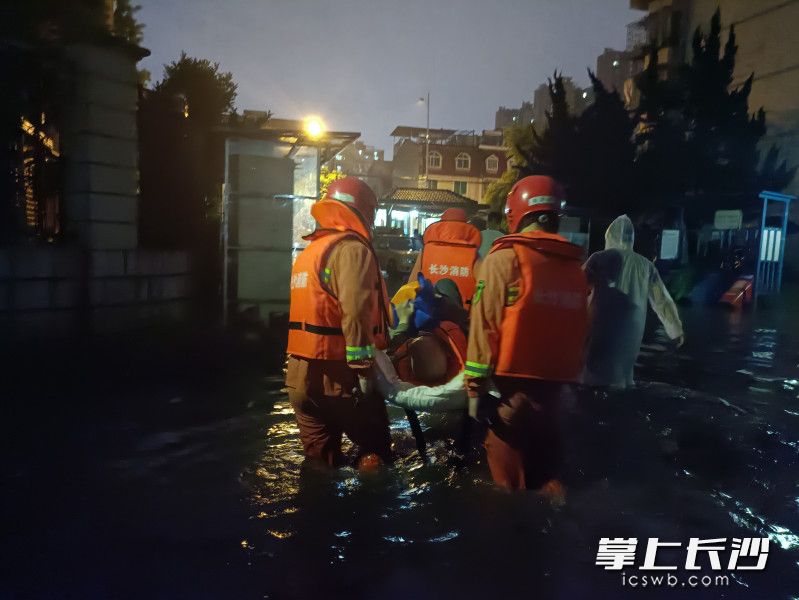 在开福区金霞苑小区内，消防救援人员将被困的老人从家中转移。长沙晚报通讯员 谢海鹏 供图