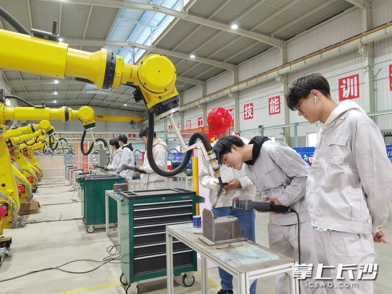 晓光工匠学院内，工人们正在操作机器。