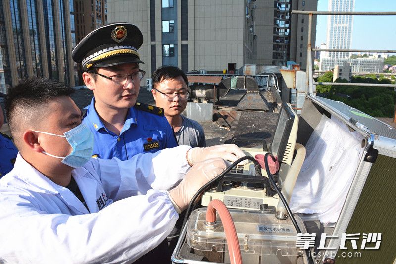 执法人员上门对餐饮企业油烟排放情况进行检测。 全媒体记者 周游 通讯员 高兴 摄