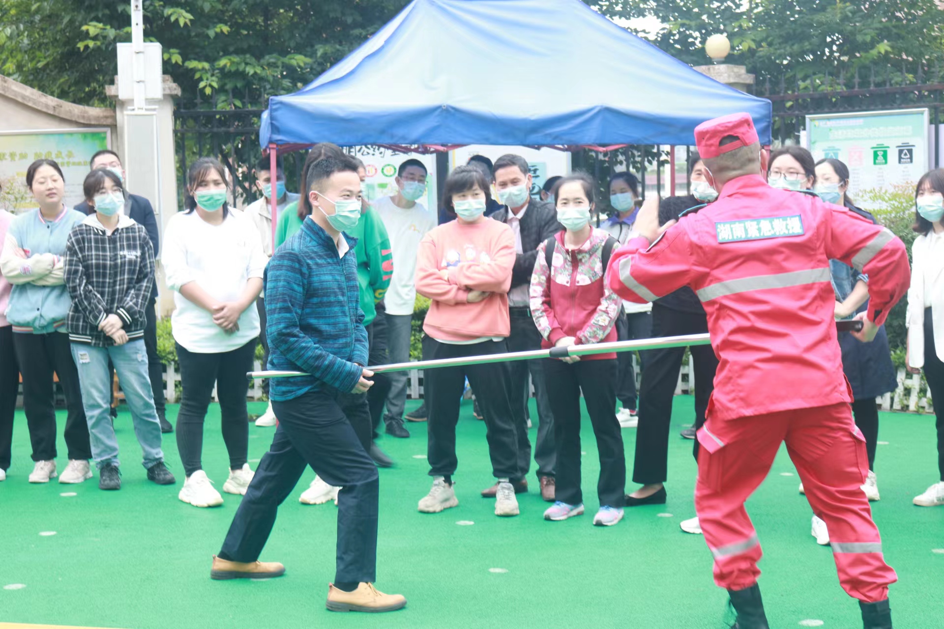 教官告诉老师和家长们怎样用防暴武器制服歹徒。