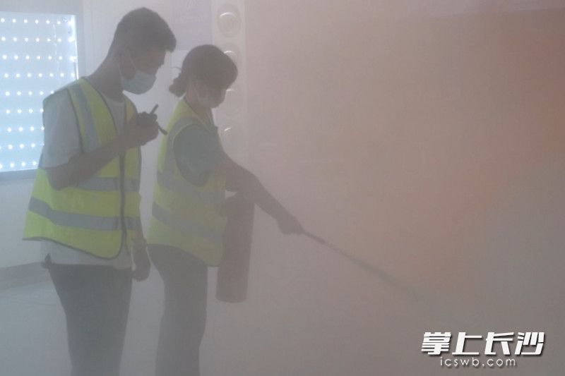 演练中，工作人员使用灭火器控制初期“火灾”。
