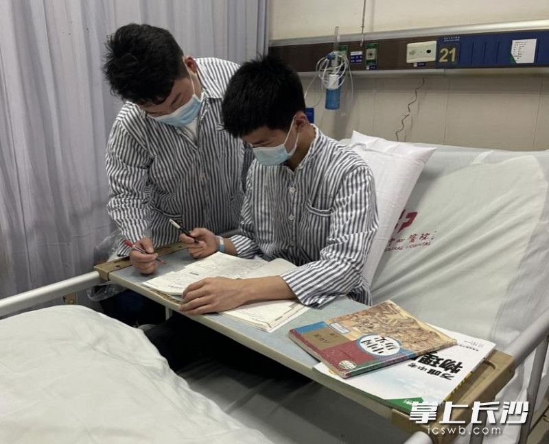 治疗期间，小峰在病房指导小智学习。   医院供图
