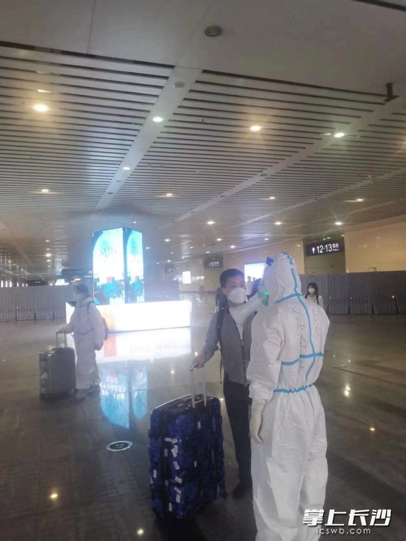 来自长沙晚报的志愿者正在引导到站旅客。
