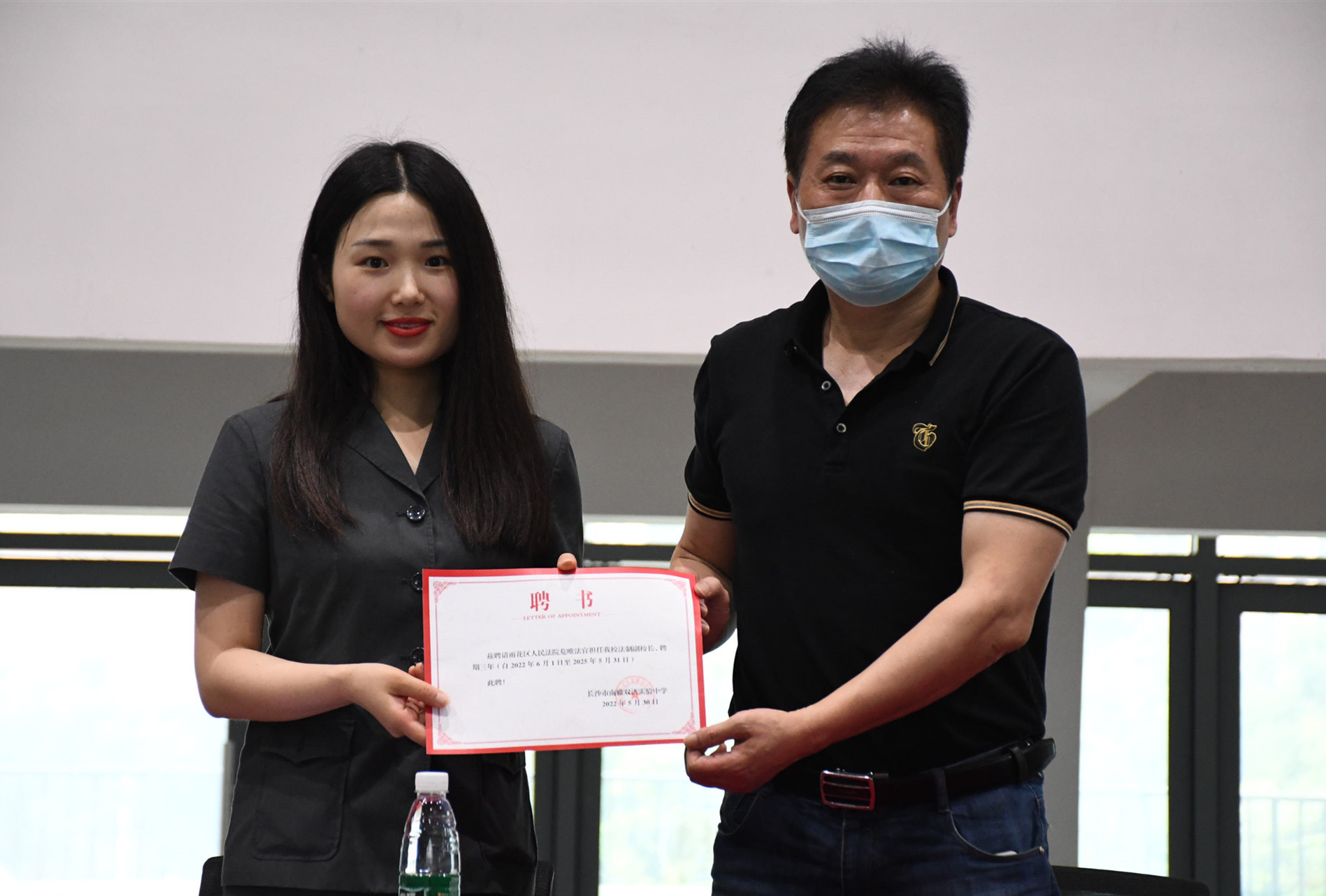 南雅双语实验中学校长卢奇灿（右）向危唯颁发法治副校长聘书。
