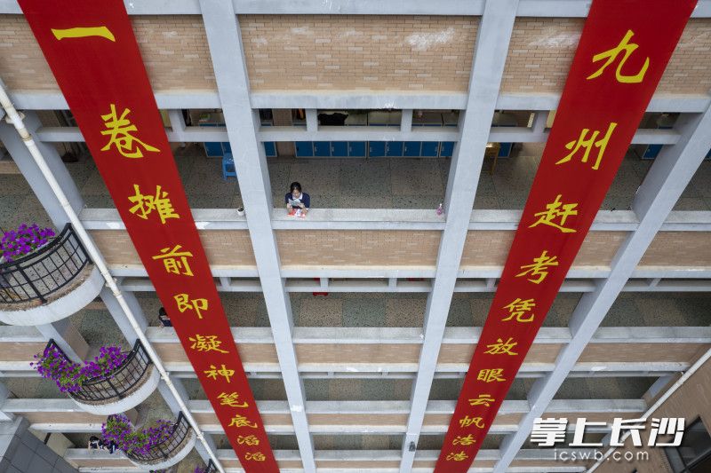 5月30日晚6时，长沙市第六中学明远楼，一位女生抽空在走廊上复习。均为长沙晚报全媒体记者 郭雨滴 周数邑 摄影报道