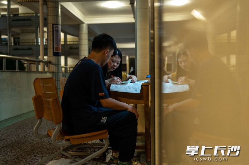 长郡中学晚自习，一名老师在教室外为学生答疑。