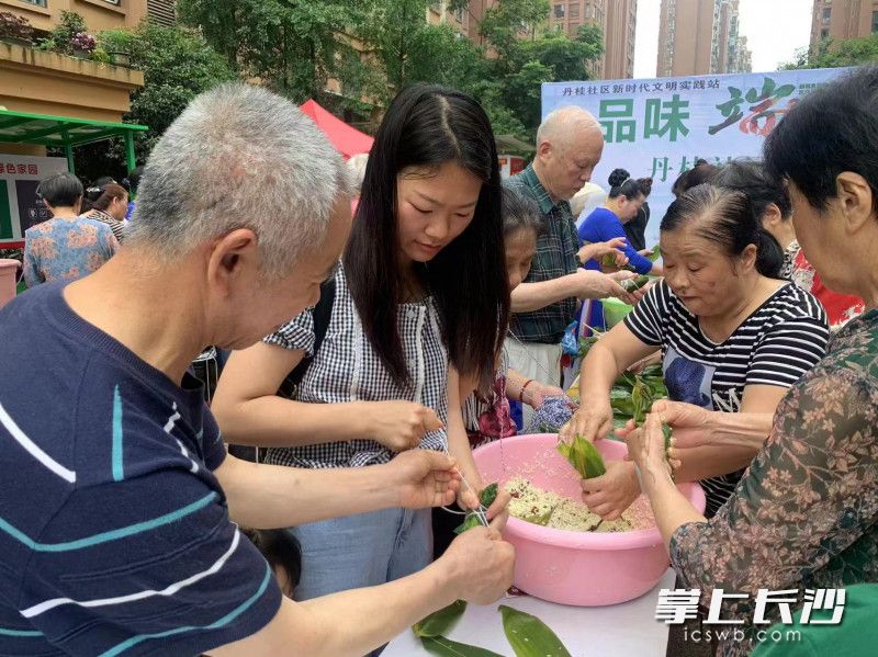 在丹桂社区，居民们参与包粽子活动。