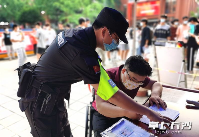 民警将残疾考生接至考点门口，并对接考点工作人员开辟绿色通道。长沙晚报通讯员 马武泽 供图