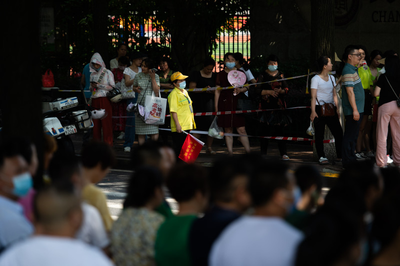 在长沙市实验中学考点，身着黄色制服的交通指挥员维持着现场秩序。