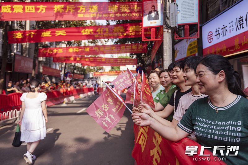 在麓山国际实验学校考点前，家长们正为考生加油鼓劲。均为长沙晚报全媒体记者 郭雨滴 摄