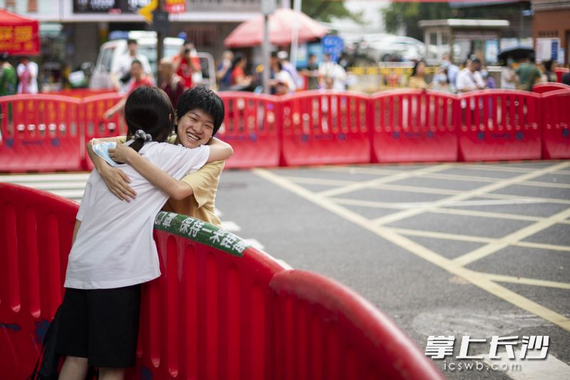 长沙市一中考点，一位已经被国外大学录取的同学来为参加高考的同学加油鼓劲。长沙晚报全媒体记者 黄启晴 摄