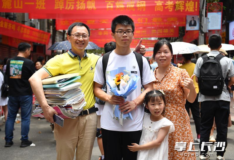麓山国际实验学校考点外，接到考生的家长一起合影。长沙晚报全媒体记者 郭雨滴 摄