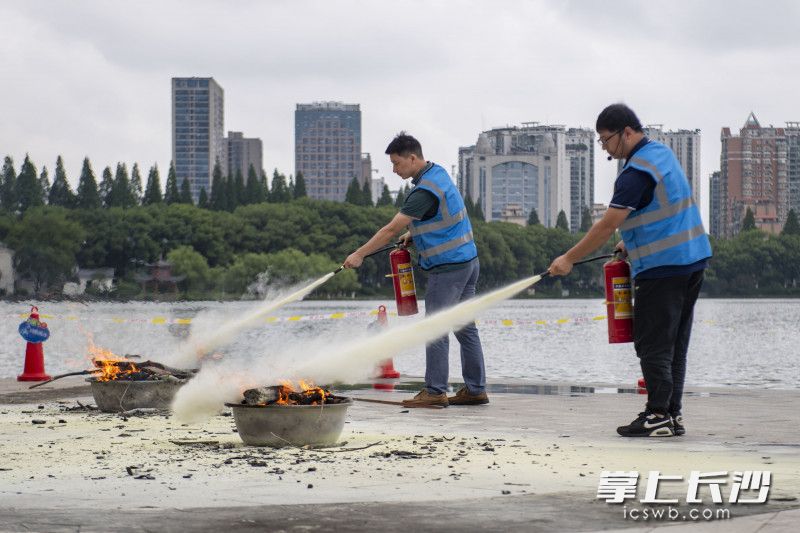 长沙城管战线各单位的参赛人员在进行灭火器灭火安全技能大比武。