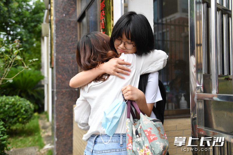 在湖南师大附中星城实验中学考点外，一位考生与母亲拥抱后进入考场。长沙晚报全媒体记者 郭雨滴 摄