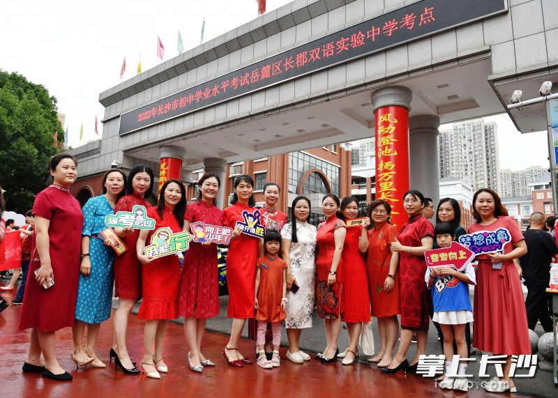 长郡双语实验中学考点外，考生家长穿旗袍举着应援牌为考生加油。长沙晚报全媒体记者 郭雨滴 摄