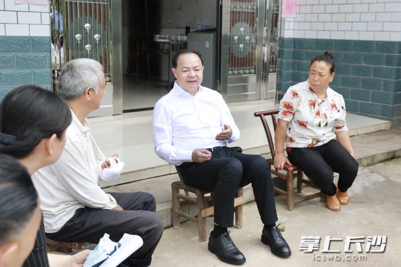 郑建新与脱贫户罗勇亲切交谈。图片均由刘书勤 摄