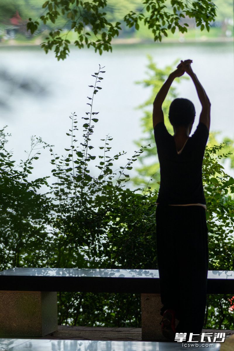 一位女士在湖边凉亭里舒展筋骨。长沙晚报全媒体记者 董阳 摄