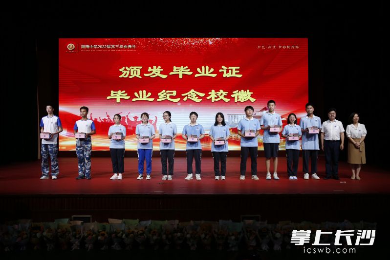 校领导为各班代表发放毕业证和周南中学校徽纪念品。均为学校供图