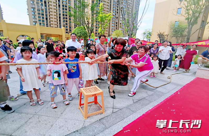 禁毒拔河赛中，两名居民感受“毒品的威力”。