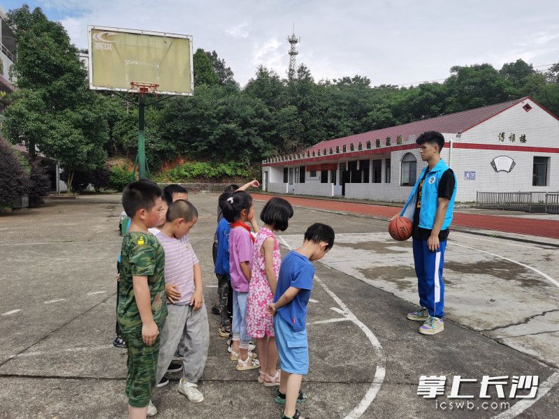 志愿者给学生上篮球课。