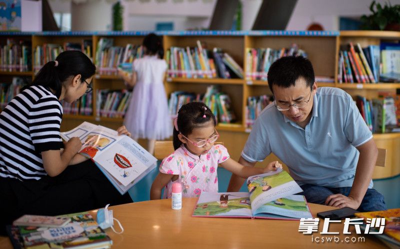 家长陪着孩子一起看书。