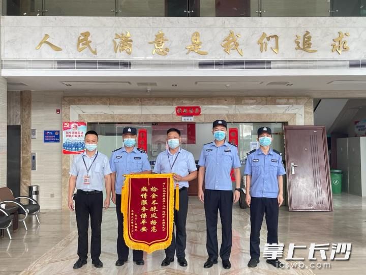 民警及工作人员收到“拾金不昧风格高 热情服务保平安”字样的锦旗。